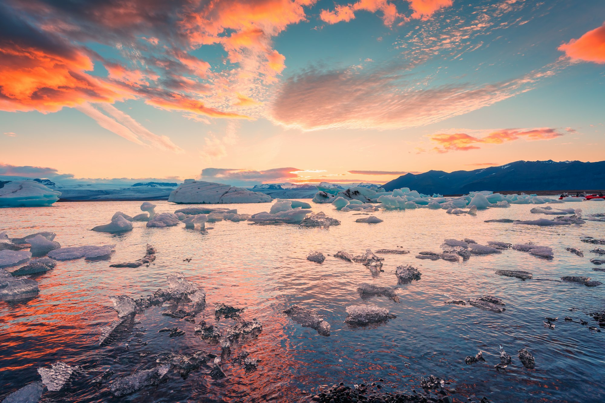 Sunset over iceberg and ice breaking floating in Jokulsarlon glacier lagoon